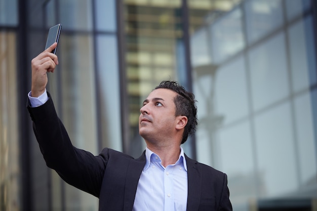 Foto empresario hablando al móvil en entorno urbano