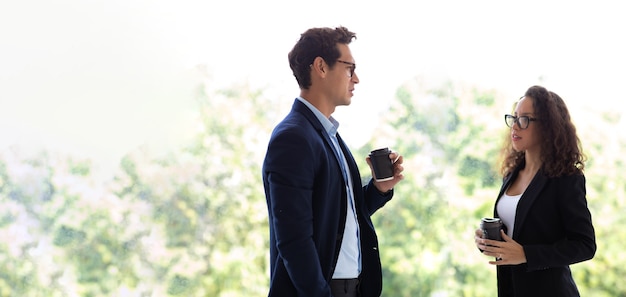 Empresário hispânico e empresária descansando, conversando e bebendo café no escritório em casa moderno. equipe profissional de empresários de sucesso.