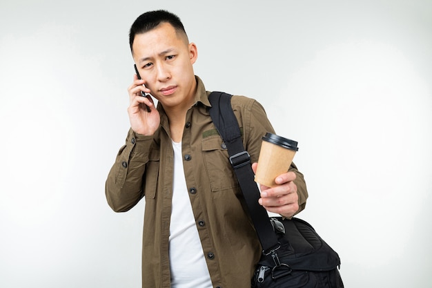 Empresario hombre asiático con un vaso de café y una bolsa en un blanco