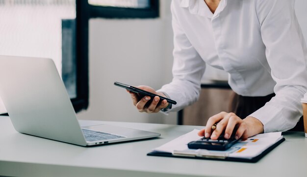 Empresario Hombre de negocios asiático y mujer de negocios discutiendo un nuevo proyecto de negocio en una tableta en una oficina moderna Encuentro en una oficina moderna Concepto casual de negocios asiático