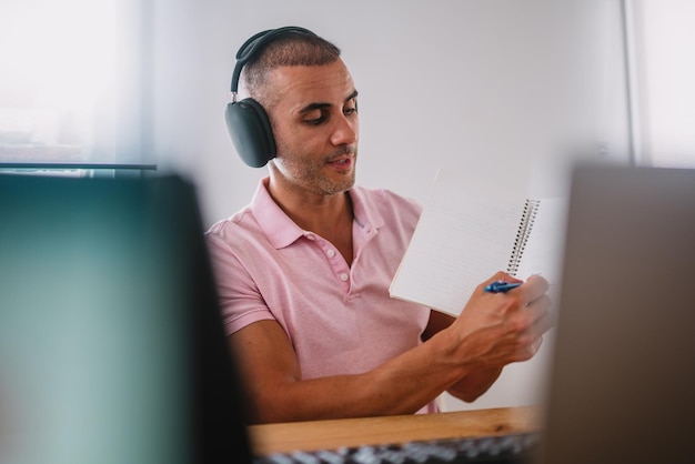 Empresario de hombre de negocios enfocado con computadora portátil y auriculares Profesional masculino usando computadora