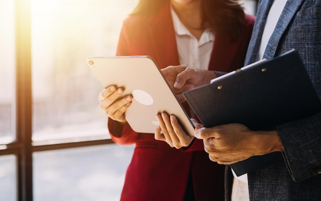 Empresário Homem de negócios e mulher de negócios asiáticos discutindo novo projeto de negócio em tablet em encontro moderno Em escritório moderno conceito casual de negócios asiático