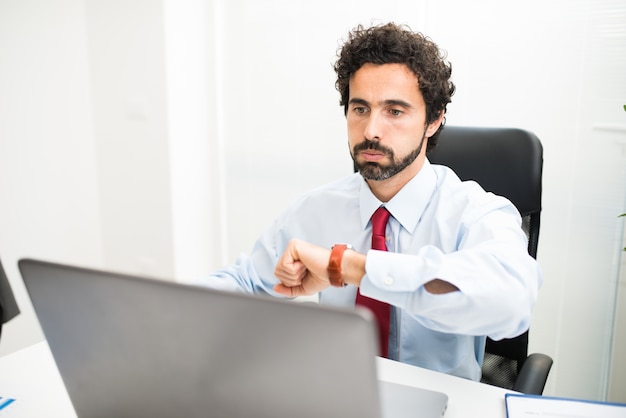 Empresário impaciente cheirando enquanto assistia seu relógio de pulso