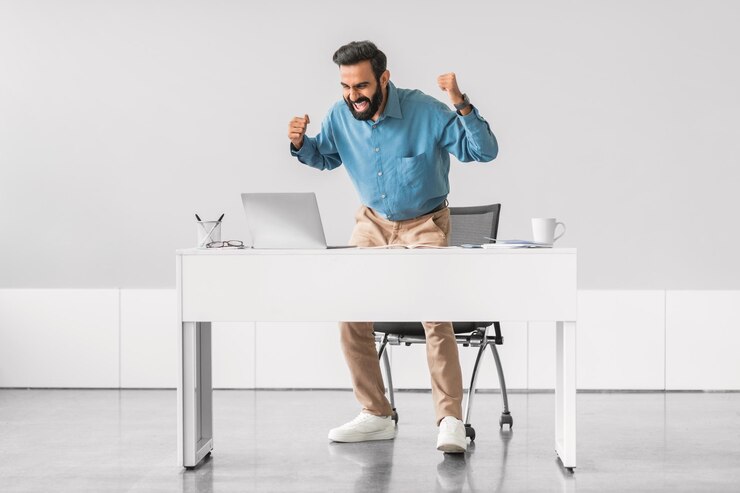 Empresario indio enérgico celebrando la victoria en su escritorio