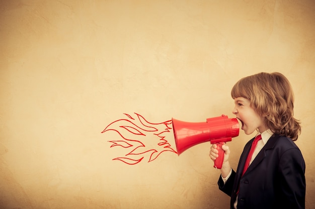 Empresário infantil segurando o megafone. Conceito de comunicação empresarial de sucesso