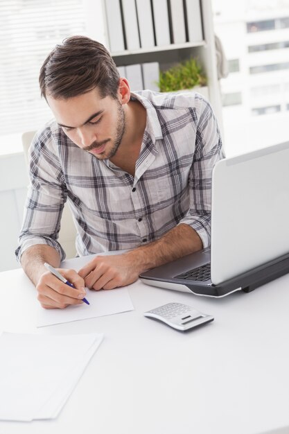 Empresario informal escribiendo en su escritorio