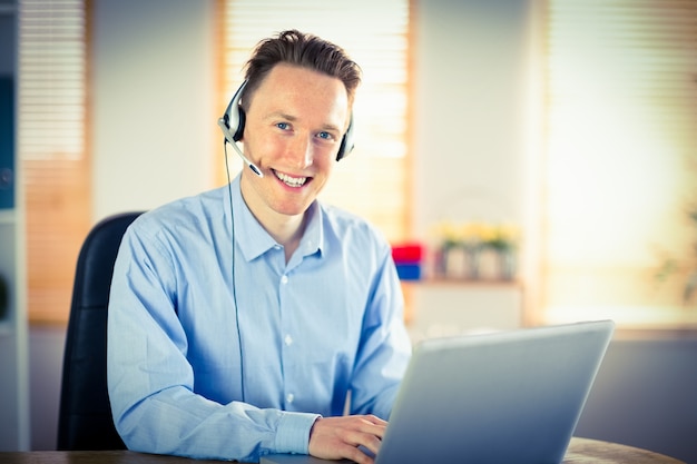 Empresario informal usando auriculares en una llamada