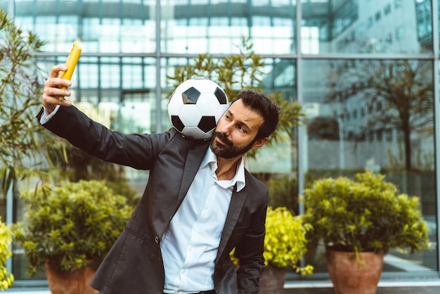 Empresário jogando com uma bola de futebol e fazendo truques de estilo livre