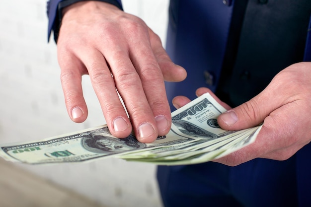 Empresário jogando dinheiro em fundo branco Homem de terno vestindo desperdiçando dinheiro jogando notas de dólares