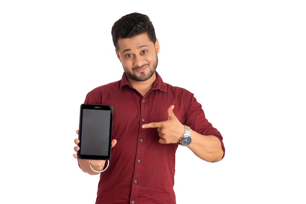 Empresário jovem bonito mostrando uma tela em branco de um smartphone ou celular ou tablet em fundo branco