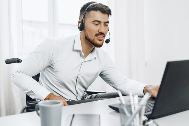 Empresario joven discapacitado trabajando desde casa con auriculares