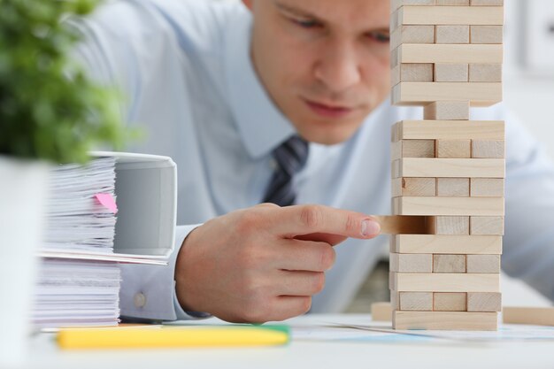 Foto empresario juega en una estrategia de mano jenga