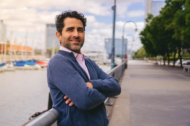 Empresario latino confiado de mediana edad con los brazos cruzados sonriendo en el espacio de copia de la cámara