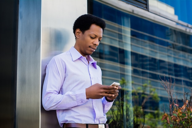 Empresário latino usando telefone celular na cidade