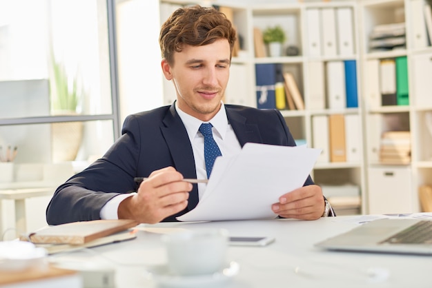 Empresário lendo documento no escritório