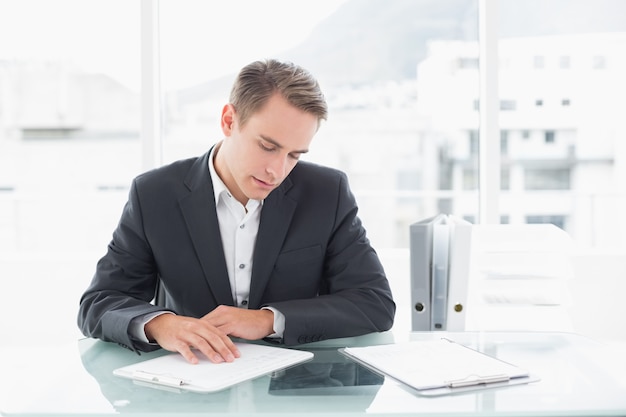 Empresário lendo documentos na mesa do escritório