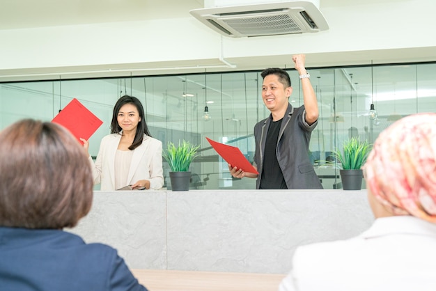 Empresário, levantando a mão e o punho em comemoração durante uma reunião com a equipe