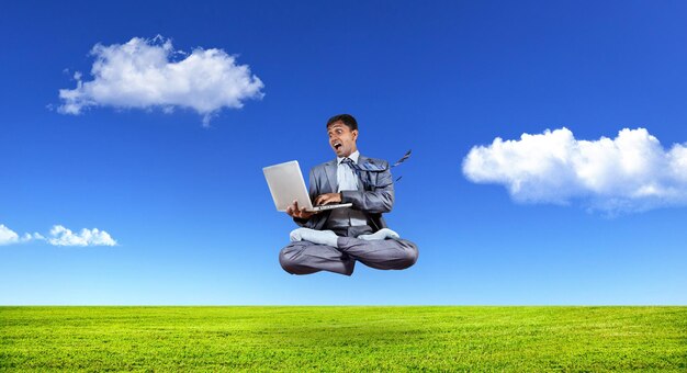 Empresario levitando con laptop