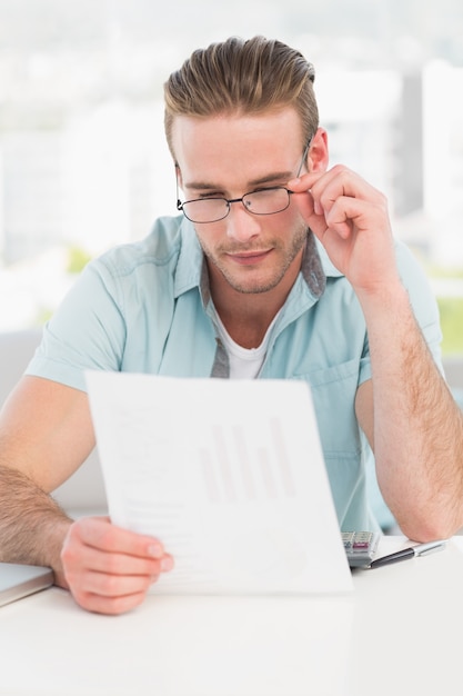 Empresario leyendo el documento en su escritorio