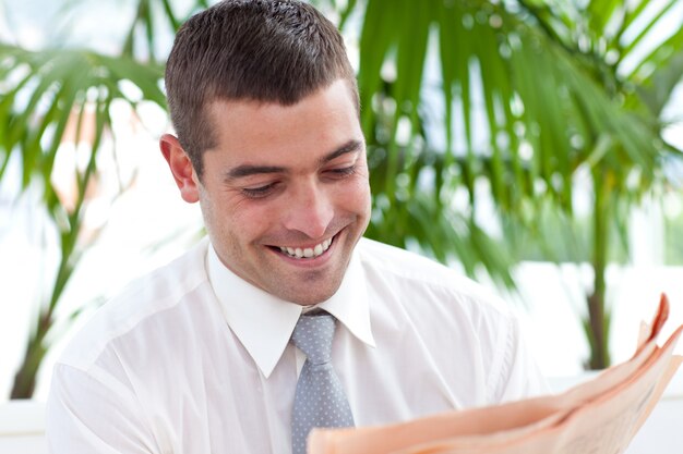 Empresario leyendo un periódico en el lugar de trabajo