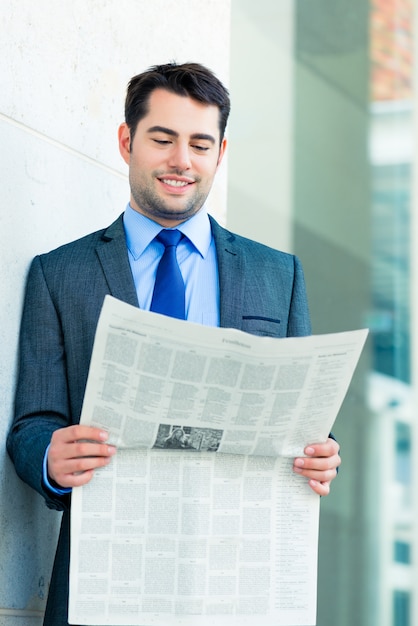 Empresario leyendo periódico de negocios