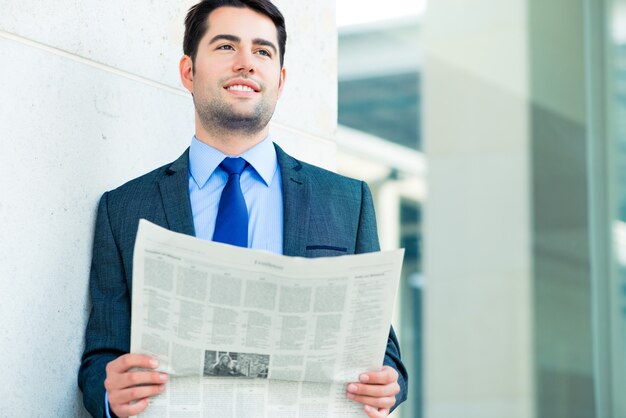 Foto empresario leyendo periódico de negocios