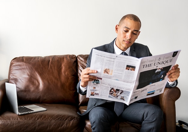 Foto empresario leyendo el periódico y tomando un café