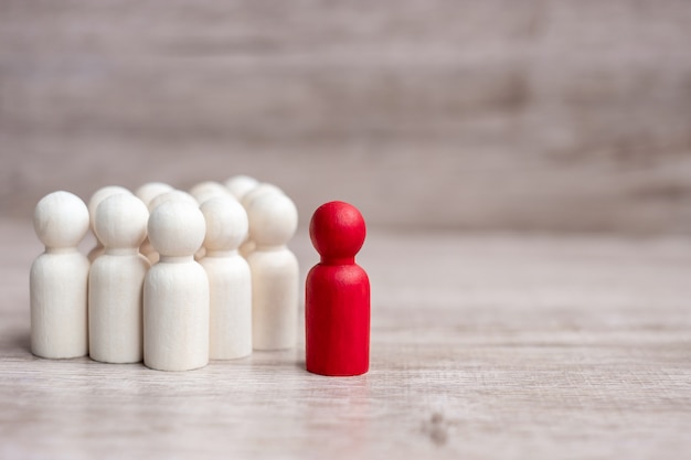 Empresário líder vermelho com multidão de homens de madeira. liderança, negócios, equipe, trabalho em equipe e conceito de gestão de recursos humanos