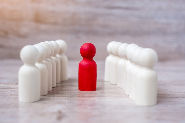 Empresário líder vermelho com multidão de homens de madeira. liderança, negócios, equipe, trabalho em equipe e gestão de recursos humanos