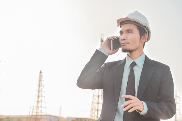 Empresario llamada celular o teléfono inteligente móvil en el sitio de construcción