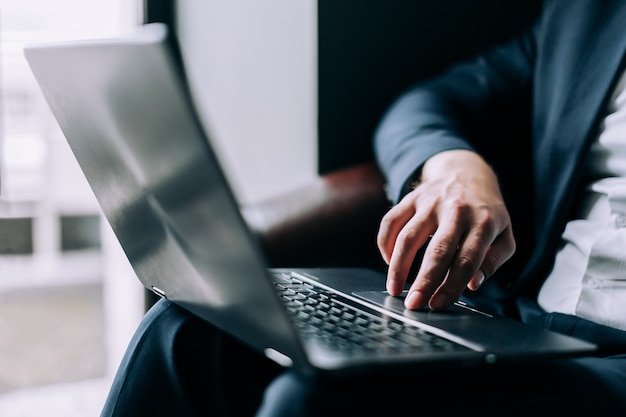 Empresario lleva la mano en un teclado de computadora portátil.