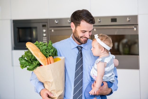 Empresario llevando verduras e hija
