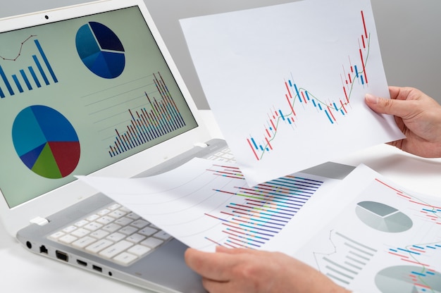 Empresario de lugar de trabajo. Cuadros y gráficos en el escritorio. Conceptos de negocio.