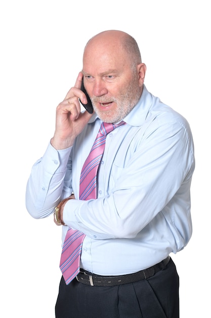 Empresario maduro hablando por teléfono, sobre fondo blanco.