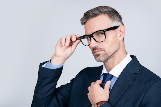 Empresario maduro con traje profesional y gafas en el espacio de copia de fondo gris