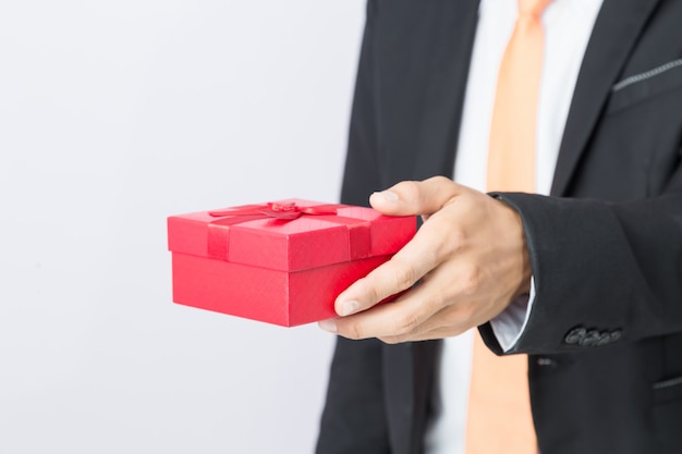 Empresário mantém a caixa de presente vermelha, fundo isolado