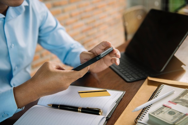 Foto empresário masculino e conceitos financeiros sobre trabalho de escritório analistas discutem negócios com smartphone e tablet como ferramenta