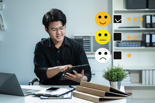 Empresario masculino con una tableta digital con casillas de comprobación califica las caras sonrientes como excelentes para la encuesta de satisfacción cliente feliz concepto de experiencia del cliente