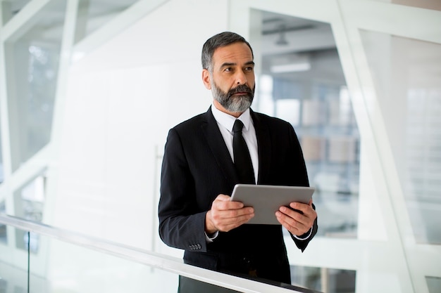 Empresario de mediana edad con tableta en la oficina