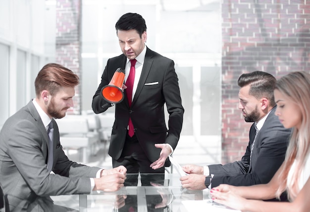 Empresario con un megáfono en una reunión con el equipo de negocios el concepto de gestión