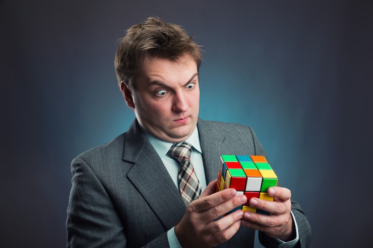 Foto empresario mirando el cubo de rubik en sus manos