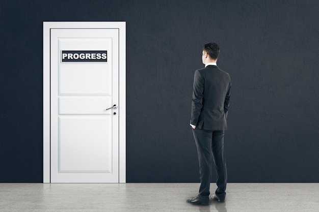 Empresario mirando la puerta con señal de progreso