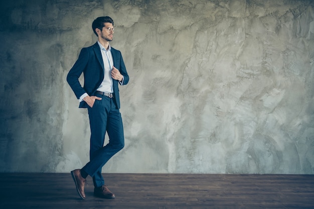 Foto empresario de moda posando contra la pared gris