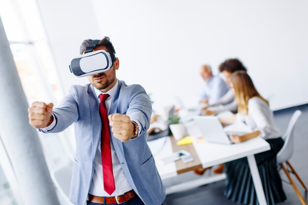 Empresário moderno com fones de realidade virtual no escritório