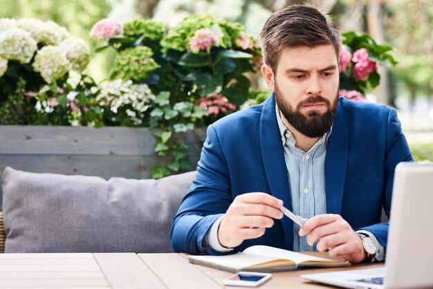 Empresario moderno trabajando al aire libre en café