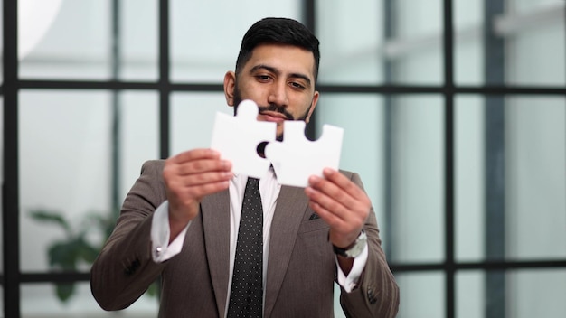 Empresário mostra quebra-cabeça branco na mão conceito de estratégia de negócios
