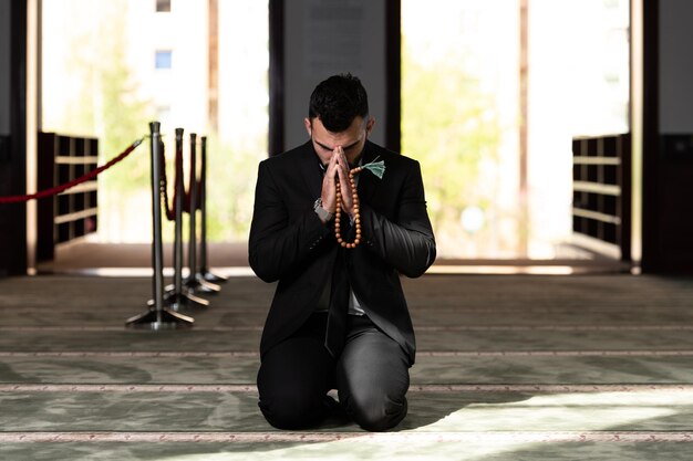 Empresário muçulmano fazendo oração tradicional a Deus Allah na mesquita