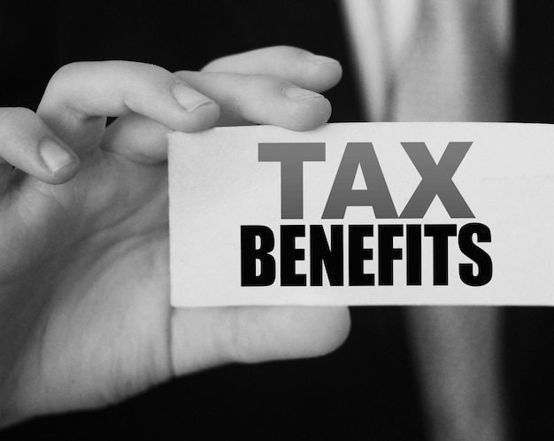 Empresario muestra una tarjeta con beneficios fiscales de texto Concepto de regulación de políticas de impuestos y tasas