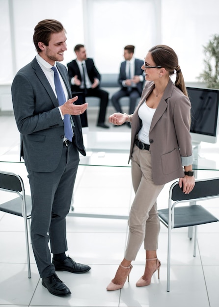 Empresario y mujer de negocios de pie en la oficina hablando con el concepto de recepcionista empresarial