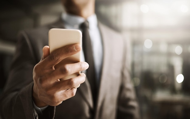 Empresario navegando en su teléfono en línea para ver sus redes sociales en la oficina de cerca Profesional corporativo en traje leyendo un mensaje sms Ejecutivo masculino revisando sus noticias